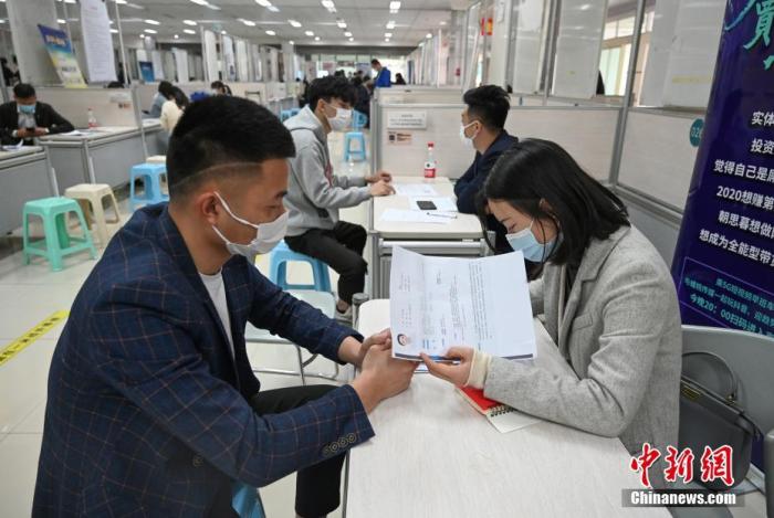 4月14日，招聘者在查看求職者簡歷。<a target='_blank'  data-cke-saved- >中新社</a>記者 王剛 攝