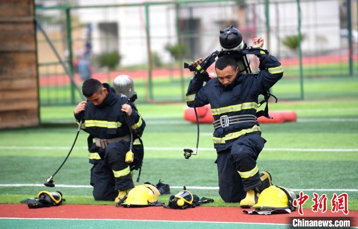 新消防員進(jìn)行穿戴空呼器展示?！⒅铱?攝