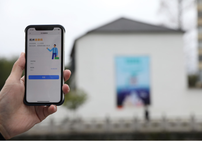 在浙江省杭州市臨安區(qū)天目山鎮(zhèn)，一名居民在“杭州健康碼”海報(bào)上掃碼申領(lǐng)個人二維碼。新華社發(fā)