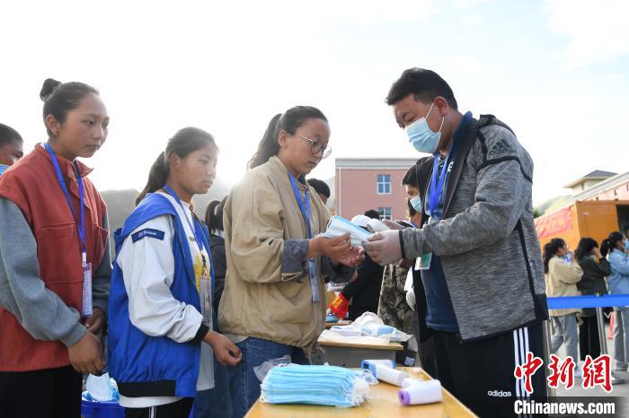 7月7日，考生在拉薩三高考點(diǎn)外領(lǐng)取口罩?！『闻罾?攝