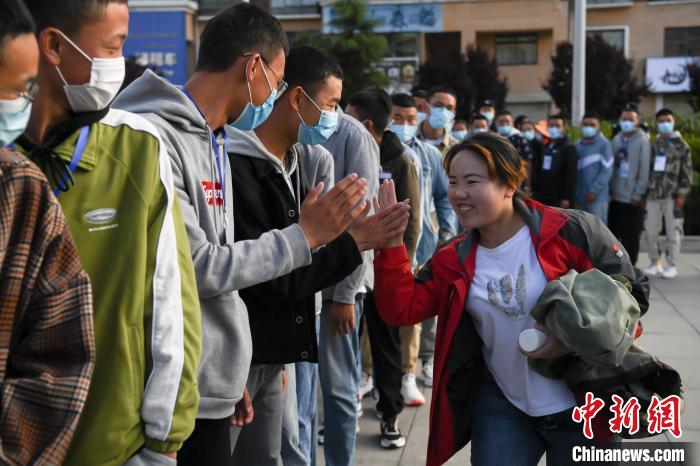 7月7日，拉薩三高考點(diǎn)外，領(lǐng)隊(duì)老師與考生擊掌鼓勁加油。　何蓬磊 攝