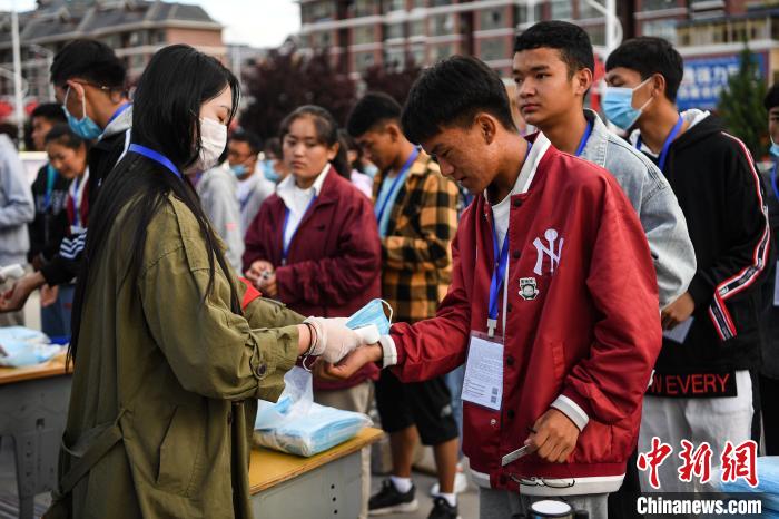 7月7日，考生在拉薩三高考點(diǎn)外測(cè)量體溫?！『闻罾?攝